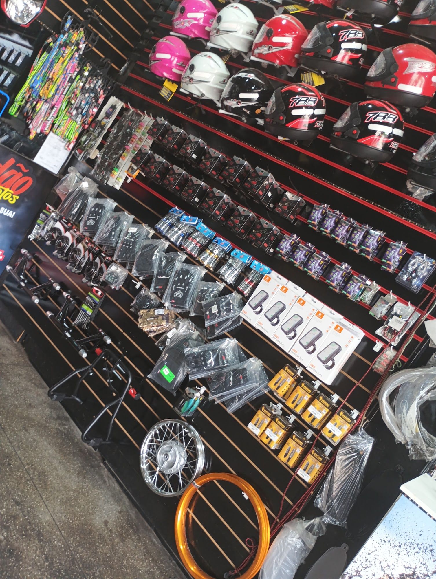 Expositor com capacetes, luvas, manetes, cavaletes e aros de moto